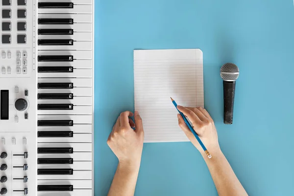 Teclas musicais, microfone e papel em branco sobre fundo azul. — Fotografia de Stock