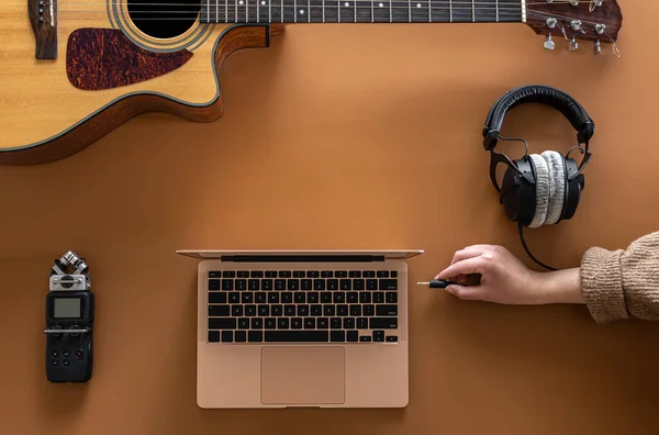 配带耳机、笔记本电脑、吉他、平铺的音乐背景. — 图库照片