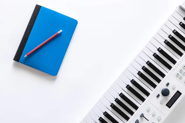 Μουσικά πλήκτρα και σημειωματάριο σε λευκό φόντο, επίπεδη lay. — Φωτογραφία Αρχείου