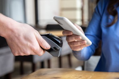 Maaş kartı, siyah postal taşıyan erkek eli ve kadın akıllı telefon getiriyor..