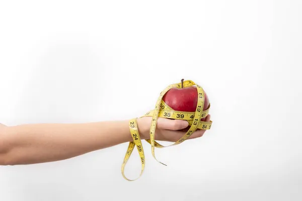 Manzana roja fresca con cinta métrica en manos femeninas, aislada. — Foto de Stock