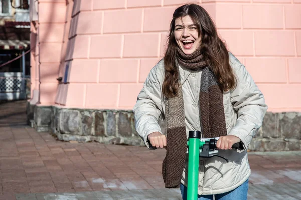 Şehirde elektrikli scooter kullanan mutlu genç bir kadın.. — Stok fotoğraf