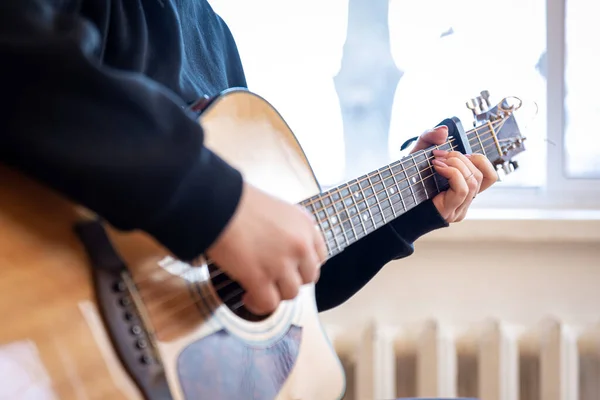 Крупный план, женские руки, играющие на акустической гитаре. — стоковое фото