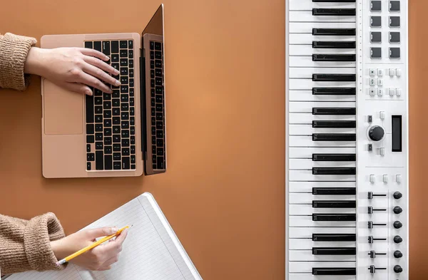 一个女人在笔记本电脑上工作，写音乐，创作歌曲，平铺地板. — 图库照片