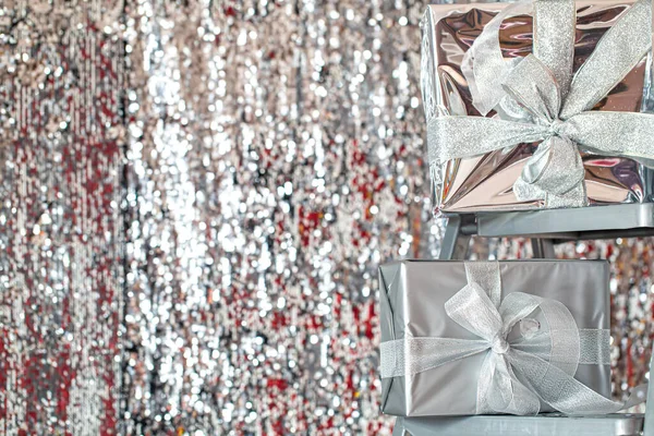 Caixas de Natal festivas de prata em um fundo brilhante. — Fotografia de Stock