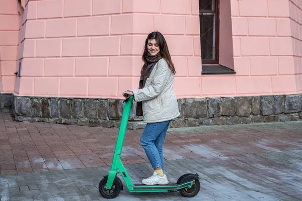 Şehirde elektrikli scooter kullanan mutlu genç bir kadın.. — Stok fotoğraf