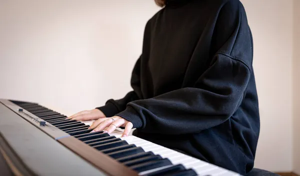 Kobiece ręce grają na klawiszach muzycznych, miękkie skupienie. — Zdjęcie stockowe