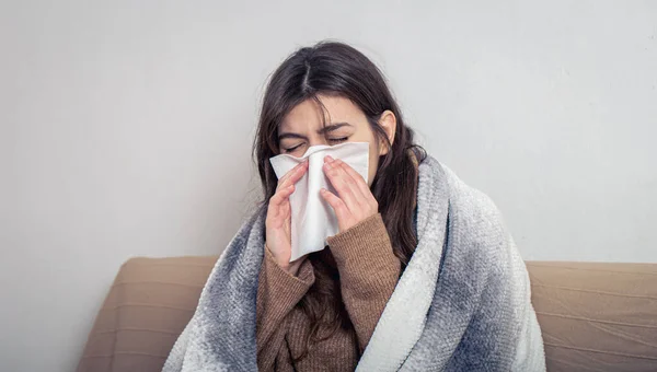 Хвора молода жінка вдома на дивані з застудою . — стокове фото