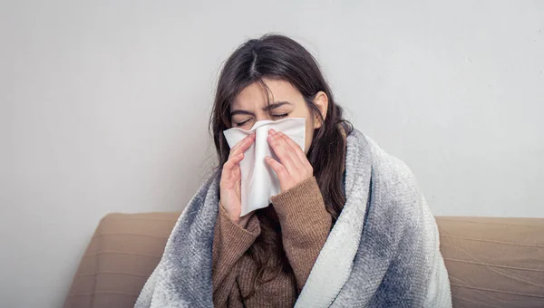 A sick young woman at home on the sofa with a cold. — Stock Photo, Image