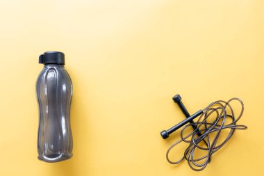 Düz kompozisyon ve sarı arka planda spor ekipmanları.