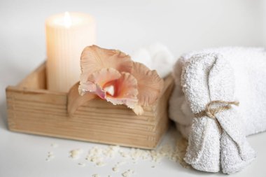 Tahta bir kutuda vücut bakım ürünleri ve Tayland orkidesi çiçekleri olan spa kompozisyonu.