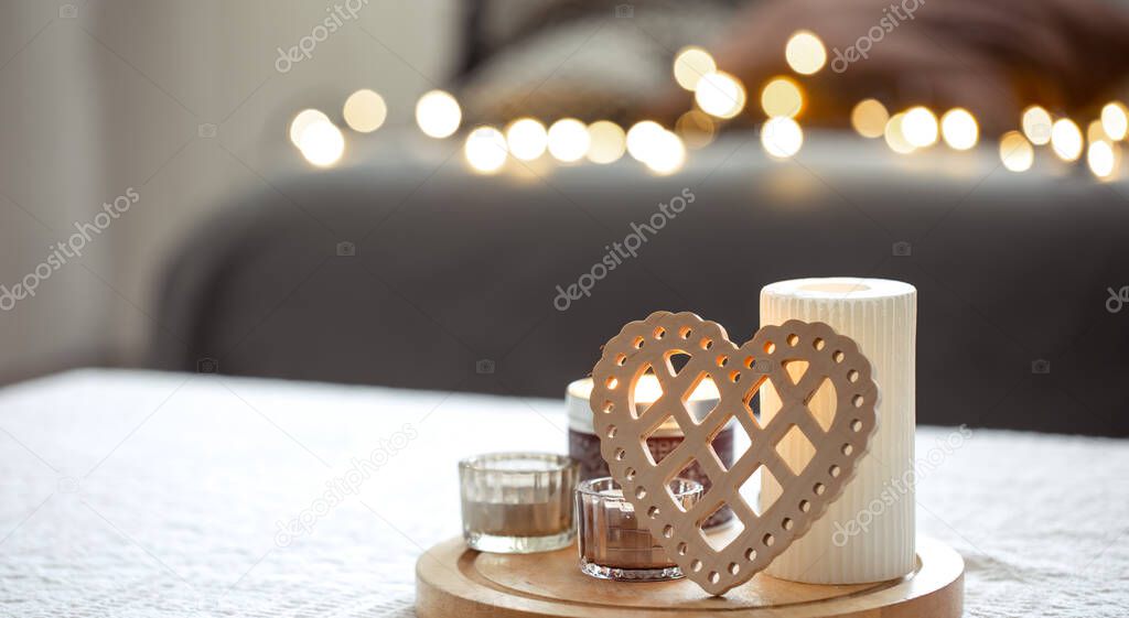 Cozy background for Valentines Day with decorative heart and candles.