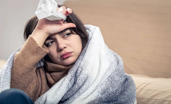 O tânără bolnavă stă acasă, înfășurată într-o pătură. — Fotografie, imagine de stoc