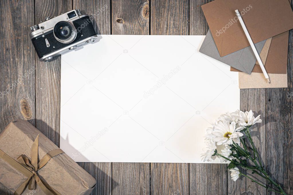 Flat lay background with retro camera and letters on wooden surface.