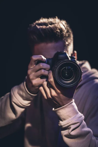 Ein Fotograf mit Kamera macht ein Foto im Dunkeln. — Stockfoto