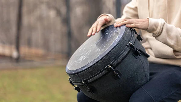 A man plays the djembe drum outside. — Stock Photo, Image
