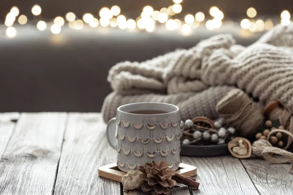 Schöne Weihnachtstasse und Kerzen auf verschwommenem Hintergrund mit Bokeh. — Stockfoto