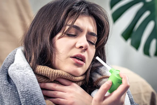 O femeie tânără bolnavă folosind spray de tuse. — Fotografie, imagine de stoc