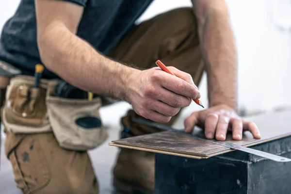 Un trabajador masculino pone suelo laminado en el suelo. — Foto de Stock