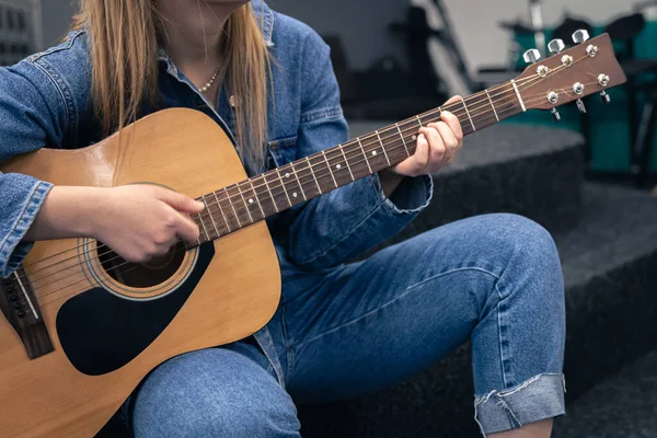 Крупный план, женщина в джинсовом костюме играет на гитаре. — стоковое фото