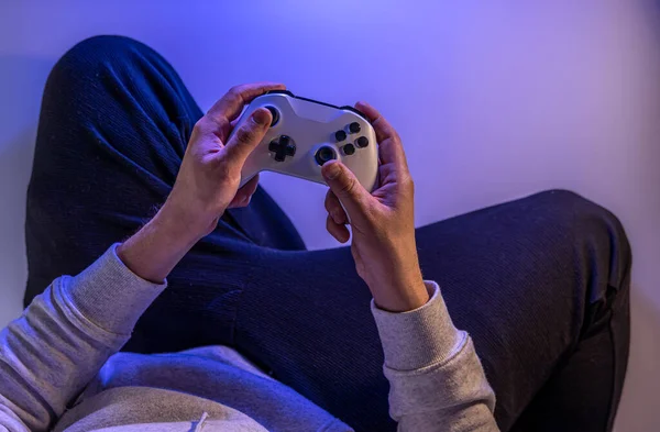 Male hands hold a gamepad on a blue background, copy space. — Stock Photo, Image
