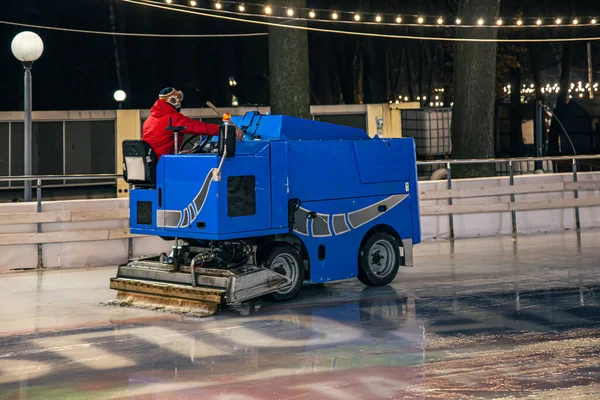 경기장에서 일하는 사람 이 푸른 현대식 얼음 세척기에 얼음 조각을 깔고 청소하는 모습. — 스톡 사진
