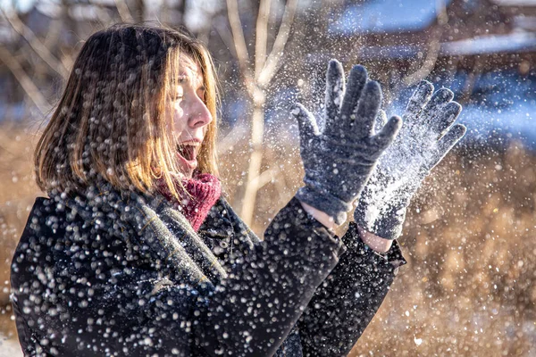 Happy young woman on a walk in winter with snow in her hands. — Stock Photo, Image