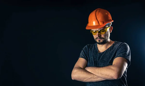 Electricista masculino en casco protector con gafas sobre fondo negro. — Foto de Stock