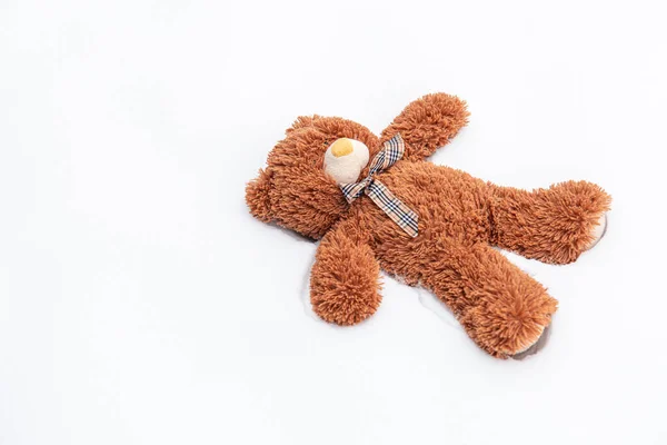 Ein Teddybär liegt allein im Schnee. — Stockfoto