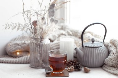 Sıcak İskandinav kompozisyonu, çaydanlık, bir bardak çay ve dekor ayrıntıları..