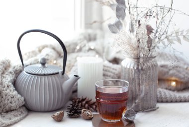 Sıcak İskandinav kompozisyonu, çaydanlık, bir bardak çay ve dekor ayrıntıları..