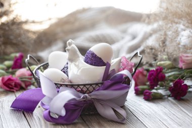 Yumurtalarla süslenmiş Paskalya kompozisyonu, mor parıltılarla süslenmiş..