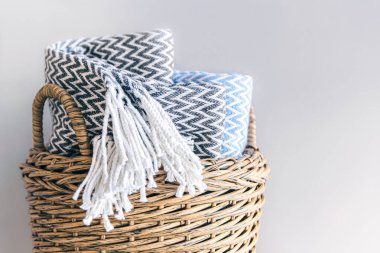 Hasır bir sepette gri bir arka planda desenli ekoseler..