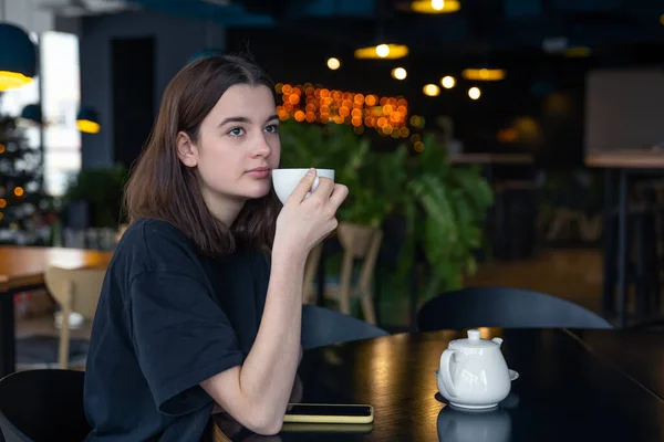 Retrato de una joven con una taza de té en un café. — Foto de Stock