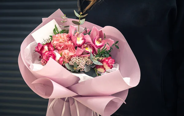 Close-up of a bouquet of pink flowers in female hands. — Stock Photo, Image