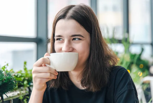 Retrato de una joven con una taza de té en un café. — Foto de Stock