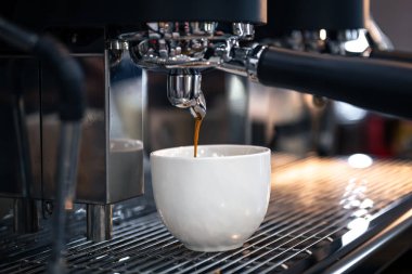 Profesyonel bir kahve makinesinde espresso hazırlama süreci, yakın plan..