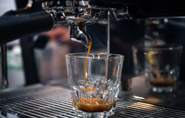 Profesyonel bir kahve makinesinde espresso hazırlama süreci, yakın plan..
