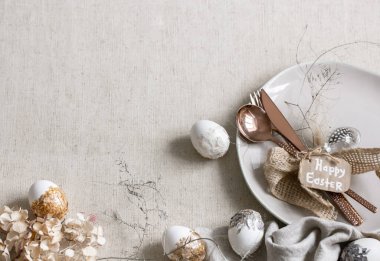 Beyaz masadaki dekorasyon detaylarıyla şenlikli Paskalya tablosu.