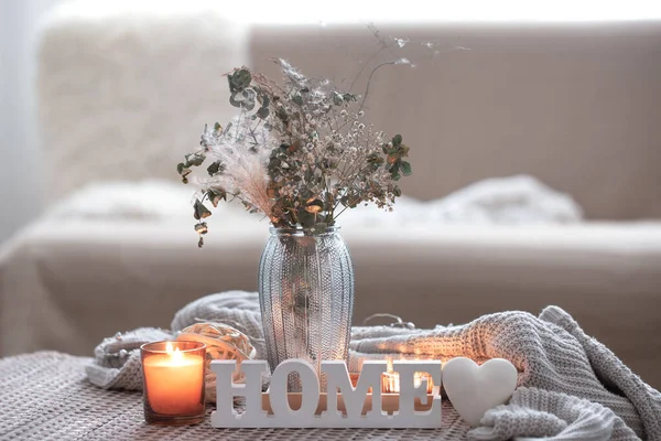 Cozy composition with decorative word home, candles and vase with dried flowers. — Stock Photo, Image