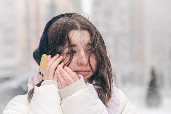 Portretul unei adolescente în aer liber cu un smartphone în vreme de iarnă zăpadă. — Fotografie, imagine de stoc