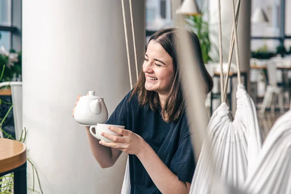 Retrato de una joven con una taza de té en un café. — Foto de Stock