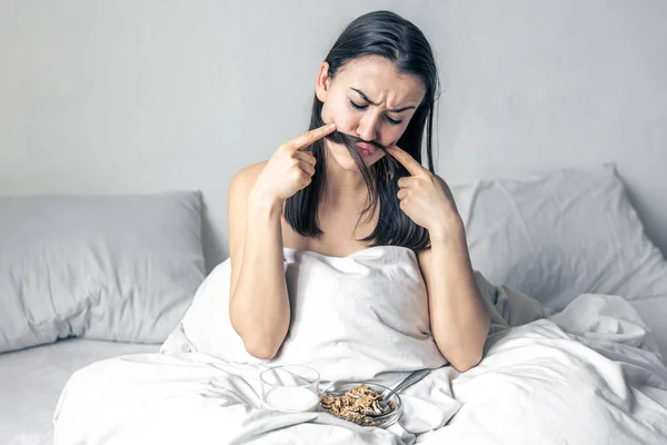 O tânără în pat alb cu cereale și lapte. — Fotografie, imagine de stoc