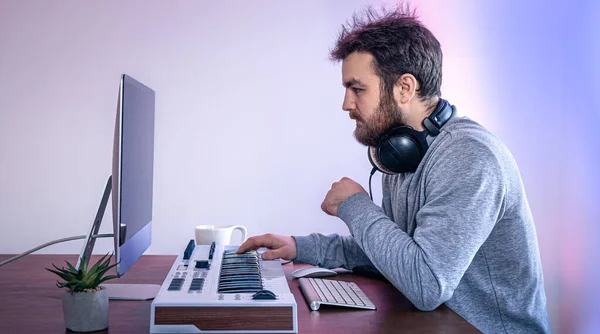 Músico masculino crea música usando computadora y teclado, músico de lugar de trabajo. — Foto de Stock