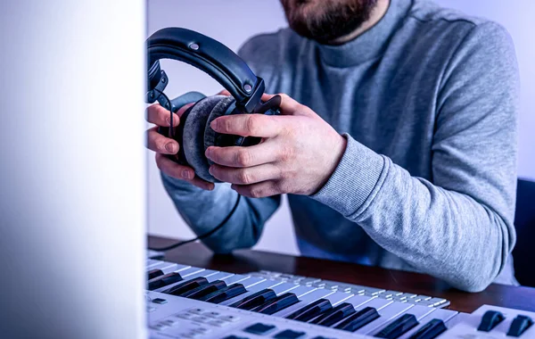 Mannelijke muzikant maakt muziek met behulp van computer en toetsenbord, muzikant werkplek. — Stockfoto