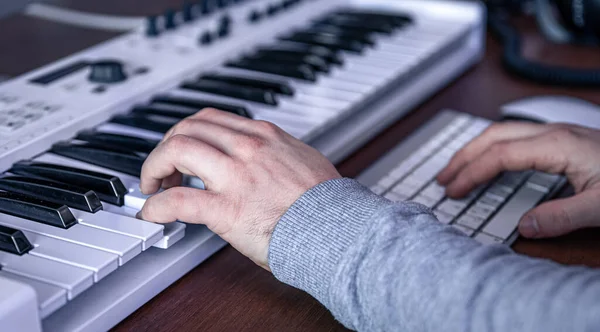 Male musician creates music using computer and keyboard, musician workplace. — Stock Photo, Image