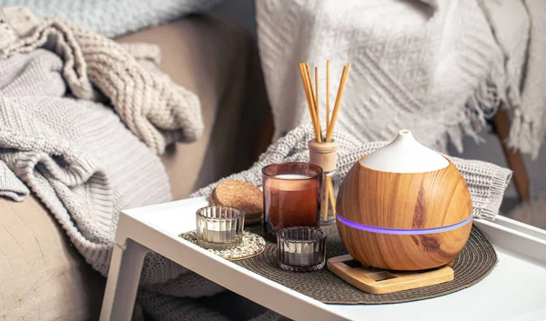 A cozy composition with an aroma diffuser and candles in a home interior. — Stock Photo, Image
