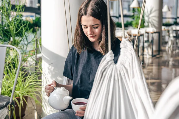 Retrato de una joven con una taza de té en un café. — Foto de Stock