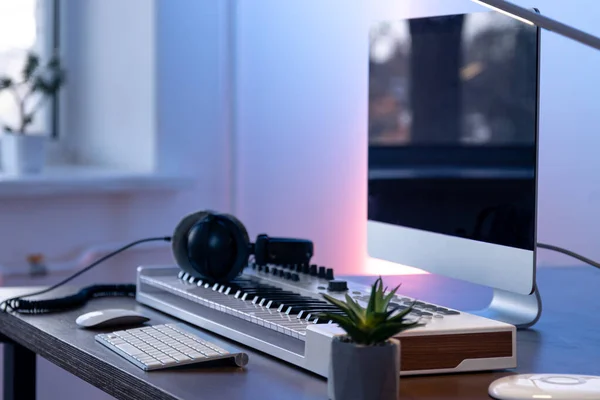 Computador, teclado midi e fones de ouvido na mesa, conceito de criação de música. — Fotografia de Stock