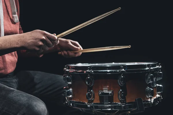 Snare trummor och trummisar händer slår trumpinnar mot en mörk bakgrund. — Stockfoto